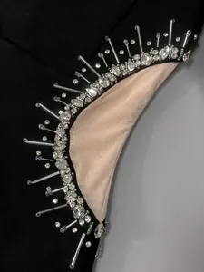 Close-up of sparkling rhinestone and bead detailing on black mesh party dress
