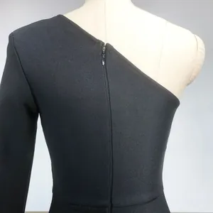 Detailed view of back zipper and ribbed texture of a black one-shoulder bandage dress