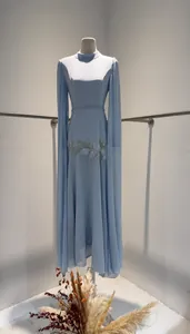 Detailweergave van blauwe avondjurk met cape-mouwen en bloemige kralenborduursels.