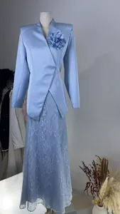 Detail view of light blue blazer with fabric flower and lace skirt set