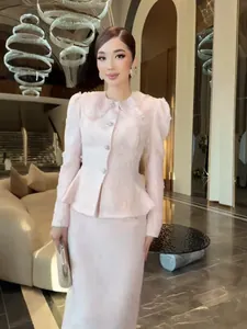 Elegante completo due pezzi in tweed rosa stile Chanel con giacca peplo e gonna midi