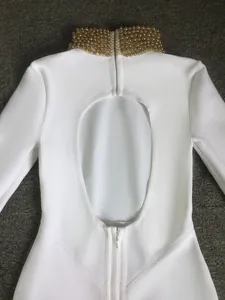 Close-up of elegant white bandage dress featuring a beaded high collar and oval back cutout