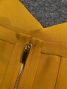 Detailed close-up of high-quality zipper on yellow bandage jumpsuit fabric
