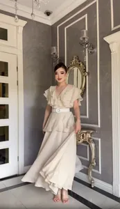 Elegantes beige rüschen besetztes V-Ausschnitt Faltenkleid mit weißem Perlen schnallengürtel.