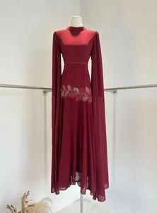 Elegante wijnrode avondjurk met prachtig kralenborduursel en lange cape-mouwen