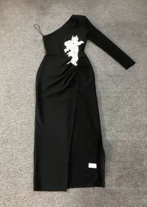 Detailed view of this elegant one-shoulder black bandage dress featuring a high side slit.