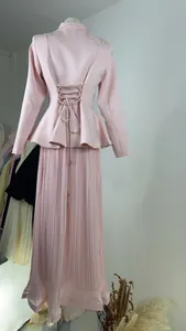 Back view of pink vintage embroidered blazer and pleated skirt set with lace-up waist detail