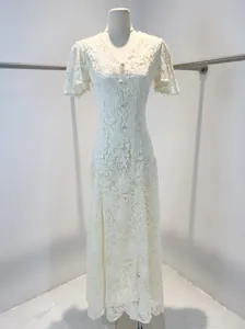 Robe élégante en dentelle blanche avec détails à franges sur mannequin.