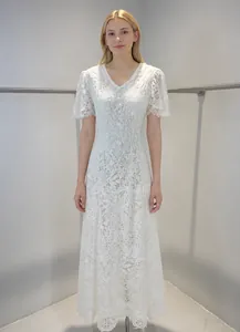 Detailed view of white heavy lace dress with V-neck and delicate floral embroidery
