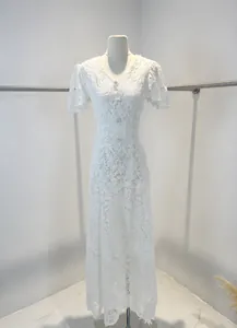 Détail d'une robe en dentelle blanche lourde avec col en V et broderie florale