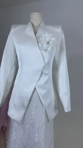 Elegant white structured blazer with large flower brooch and padded shoulders for women