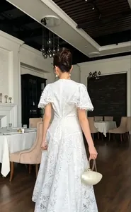 Elegant white lace dress with heavy craft floral patterns and tassel sleeve details.