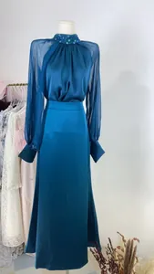 Elegant teal blue satin evening gown with sheer chiffon sleeves and beaded collar detail.