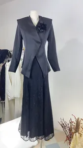 Detail view of black satin blazer and floral lace maxi skirt set on a mannequin.