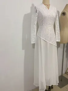 Detail view of white lace bodice and long flowing chiffon skirt of elegant maxi dress