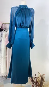 Elegant teal evening gown featuring a sequined high neck and sheer long lantern sleeves.