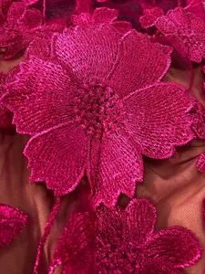 Macro detail of fuchsia 3D floral embroidery on mesh fabric for elegant lace dress