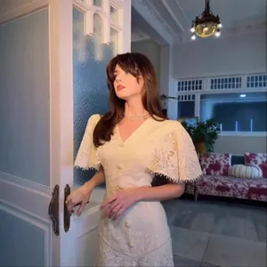 Elegant cream lace dress featuring fringe sleeves and vintage detailing on a model