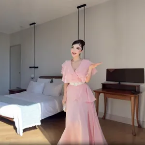 Elegantes rosa französisches Kleid mit Rüschen und Falten in Schlafzimmer-Kulisse