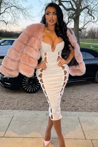 Détail d'une robe bandage blanche nervurée avec ajours et veste en fausse fourrure