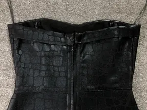 Detail of black strapless bodycon dress with bronzing crocodile texture and back zipper.
