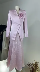 Detail view of pink satin blazer and matching floral lace skirt on a mannequin