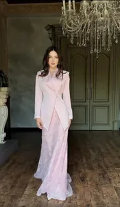 Detailed look at this elegant pink textured two-piece suit featuring a blazer and long skirt.