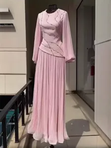 Elegant pink pleated maxi dress featuring delicate rhinestone detailing and long sleeves.