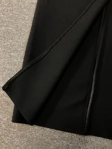 Close-up detail of high-quality black bandage dress showing zipper and fabric texture