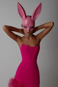 Editorial detail view of hot pink strapless bandage dress with ostrich feather hemline