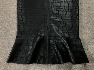 Detail view of the black crocodile pattern texture on a mermaid bandage dress hem