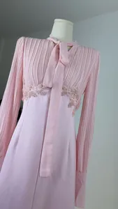 Elegantes rosa französisches Kleid mit Faltenärmeln, Schleifenhals und feinen Taillenspitzendetails.