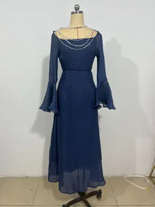Dettaglio di un abito blu scuro a maniche lunghe con elegante scollatura a catena su manichino.