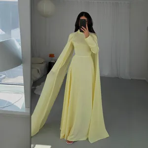Full-length view of a minimalist yellow floor-length dress with cape sleeves and fringe