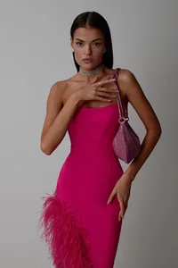 Detailed view of a high-end magenta strapless gown featuring ostrich feather trim and side slit.