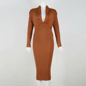 Detail view of a caramel long-sleeve bandage dress with a plunging deep V-neckline