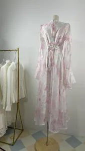 Close-up detail of a long-sleeve floral maxi dress with ruffle cuffs and lace-up back design