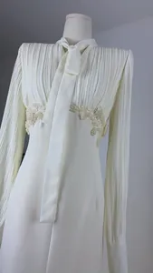 Detailansicht eines weißen Plissee-Kleides im französischen Stil mit eleganter Spitzenstickerei