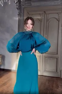 Elegant teal French evening gown with beaded high neck and puffy lantern sleeves detail.