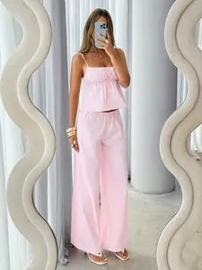 Detail view showing the fabric of the pink striped camisole crop top and wide-leg trousers