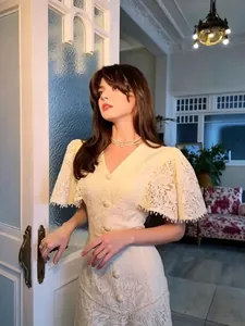 Elegant vintage style white lace dress featuring cape sleeves and pearl button details