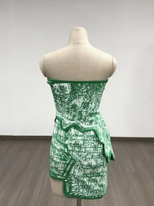 Detailed back view of a chic green and white jacquard tube top dress with asymmetrical wavy hem.