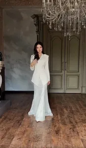 Full view of elegant white blazer and long lace skirt suit set in a luxury palace interior