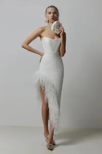 Full view of white strapless gown showing ostrich feather trim and high leg slit detail