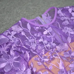 Close-up detail showing exquisite purple floral lace embroidery on sheer mesh dress