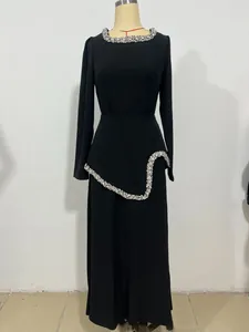 Nahaufnahme eines eleganten schwarzen bodenlangen Kleides mit feinen Strassverzierungen
