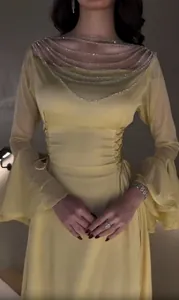 Dettaglio del vestito lungo giallo con scollo a catena strass e maniche a campana