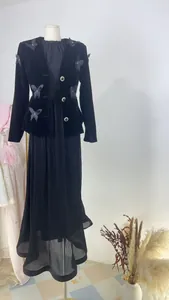 Detail view of retro black velvet suit with butterfly appliqués and pleated skirt