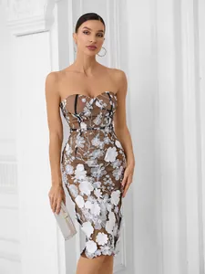 Detail of elegant strapless midi dress with white floral embroidery on black mesh