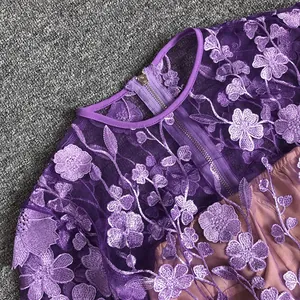 Detailed view of intricate purple floral lace embroidery on an elegant evening gown